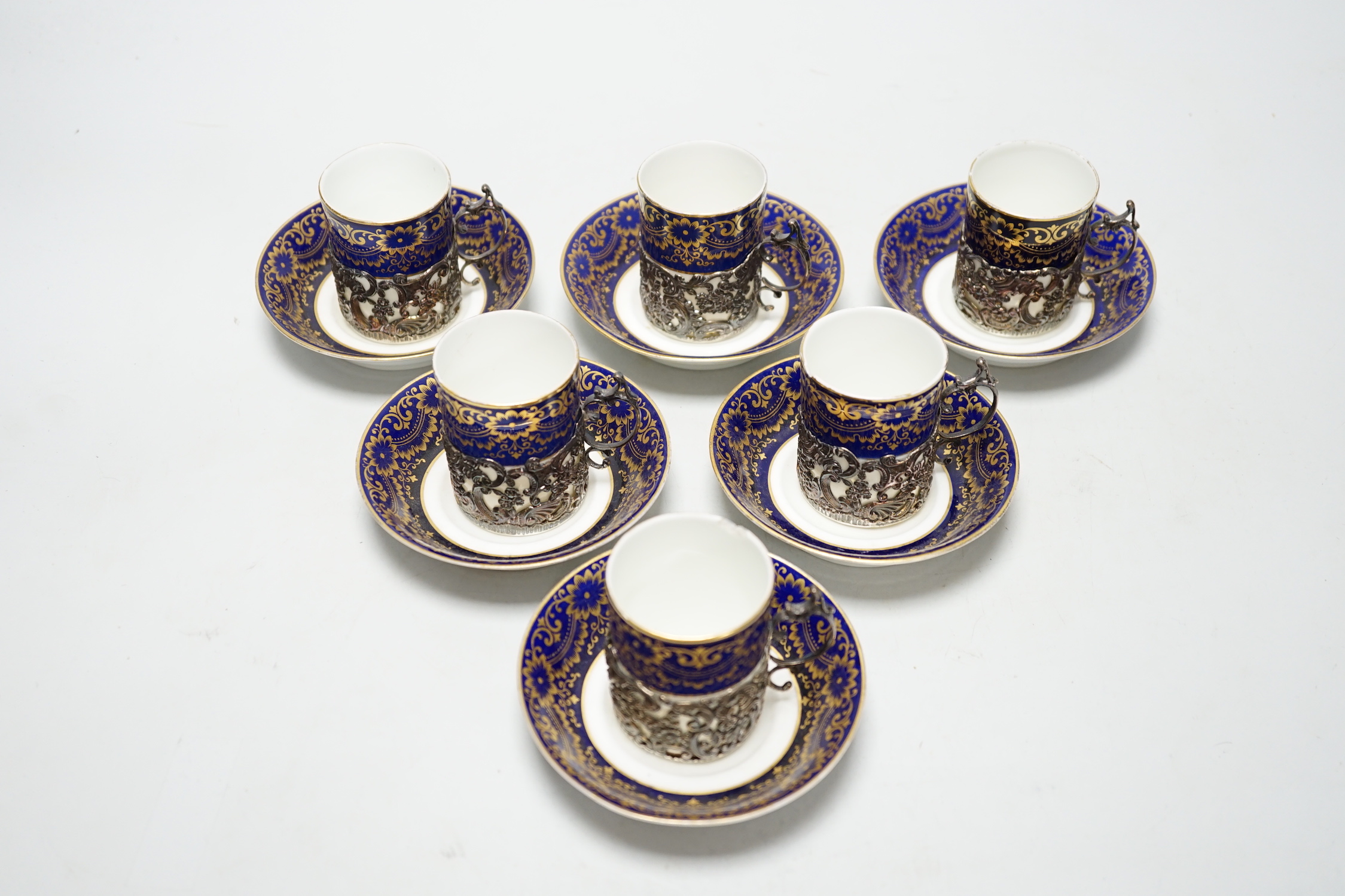 A set of six silver jacketed porcelain cups and saucers